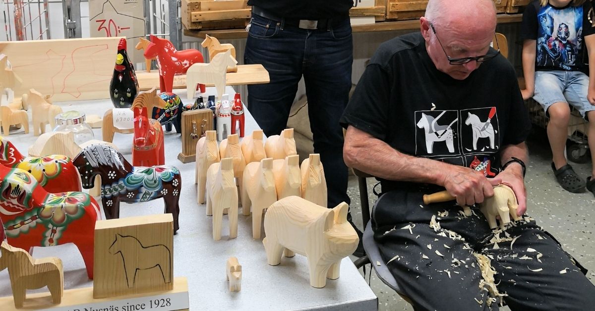 a man is making a dala horse