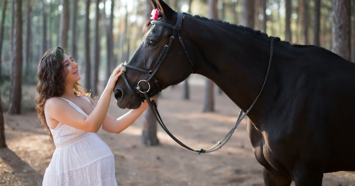 a pregnant woman with a black horse