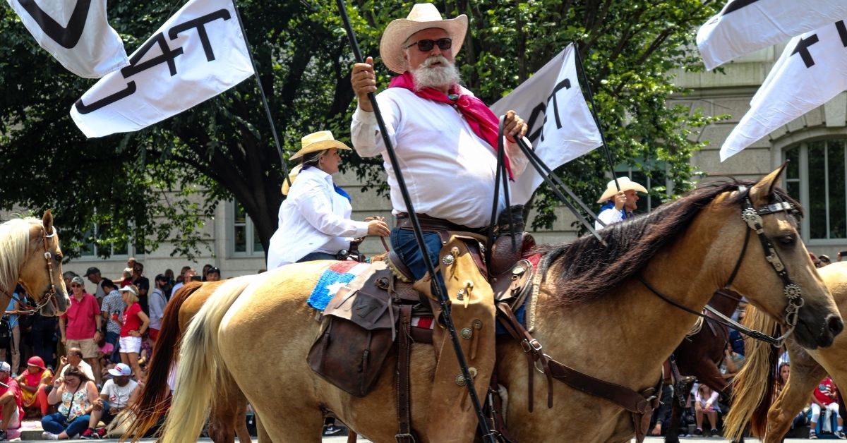 cowboy riding horse on city parade