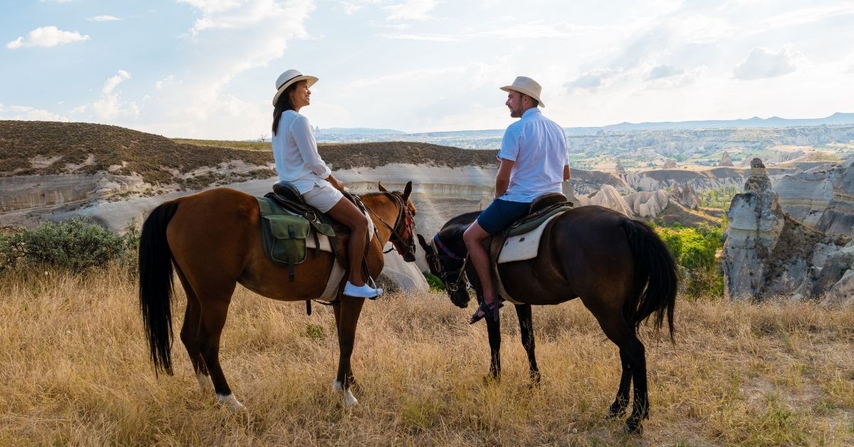 A young couple is riding horses in the Grand Canyon